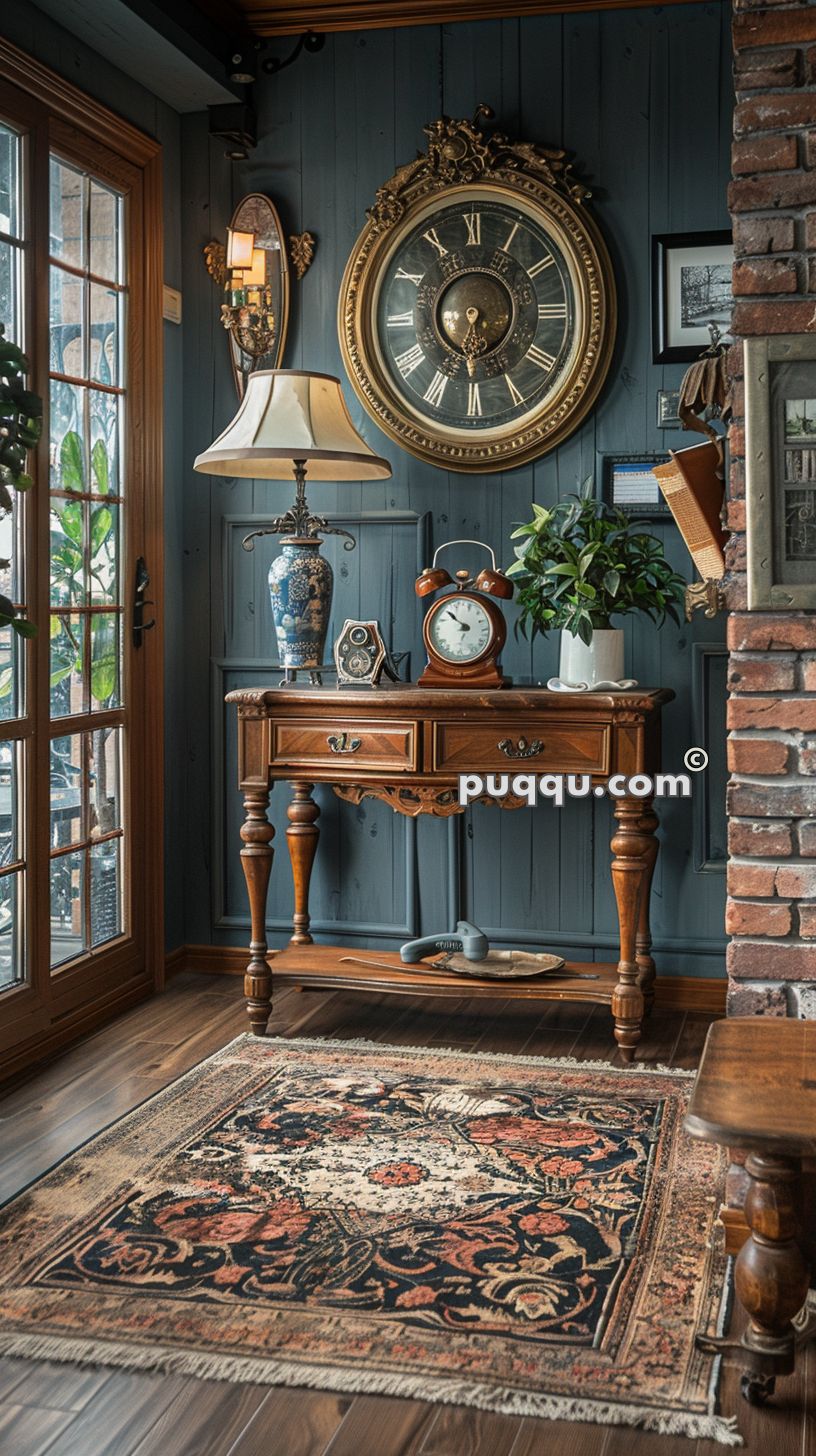 Vintage-style interior with a wooden side table, decorative table lamp, two clocks, and a potted plant. A large ornate wall clock hangs above the table. The room features brick and wood-paneled walls, a patterned rug, and a view of a glass door.