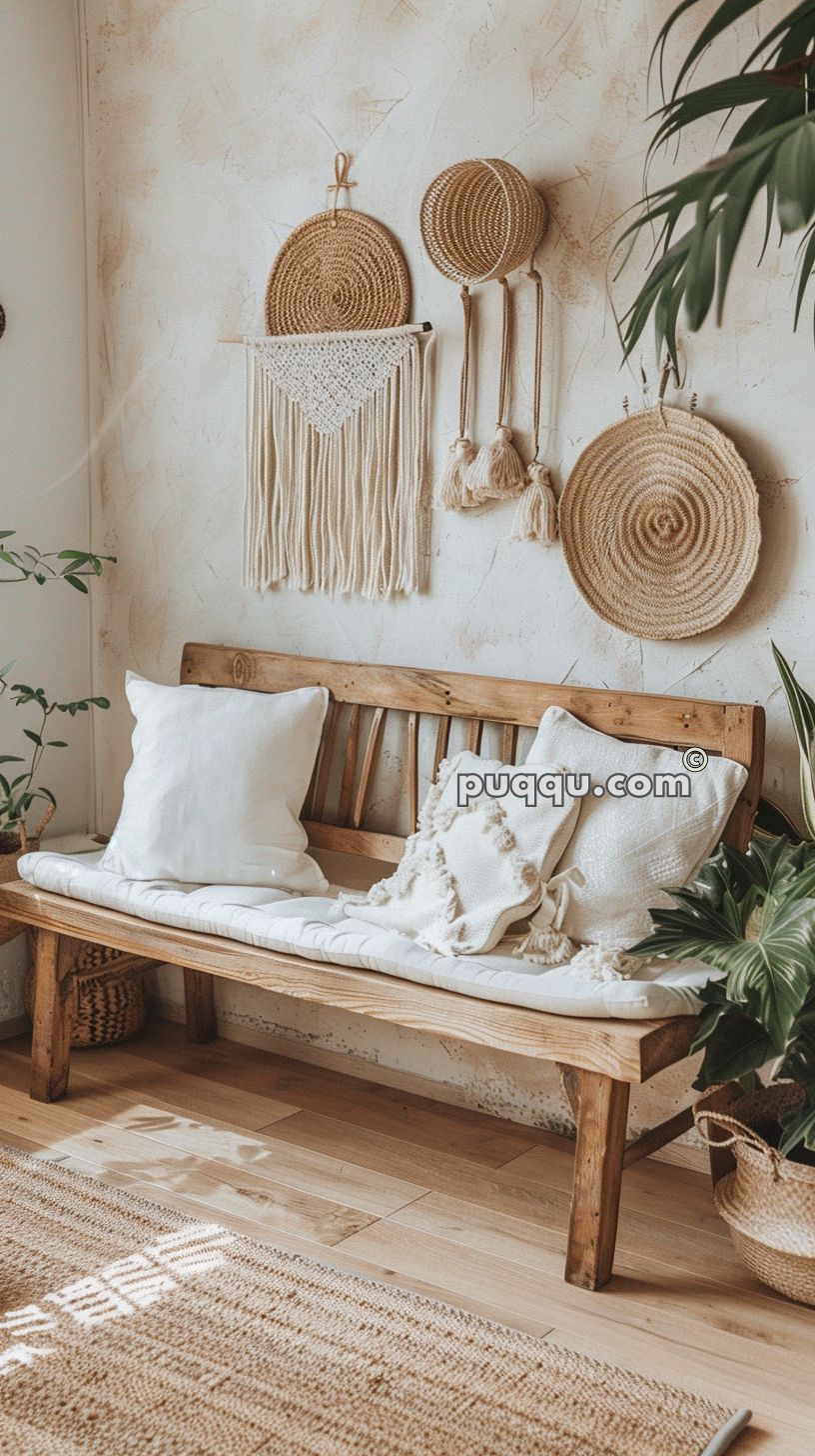 Wooden bench with white cushions and pillows, surrounded by woven wall hangings and green plants in a cozy, rustic room.