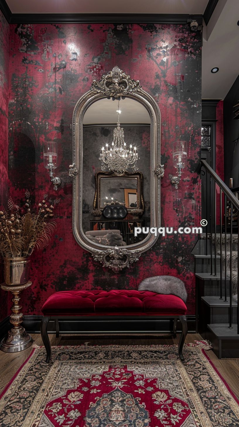 Ornate interior with a large decorative mirror, a crystal chandelier, a red velvet bench, and a Persian rug, featuring a black and red textured wallpaper background.