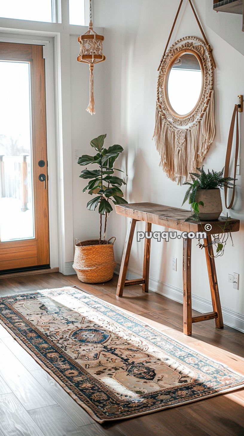 Entryway with a wooden door, a potted plant in a woven basket, a rustic wooden table with a plant on it, a round mirror with a macrame frame, a macrame hanging decoration, and a patterned rug on hardwood flooring.