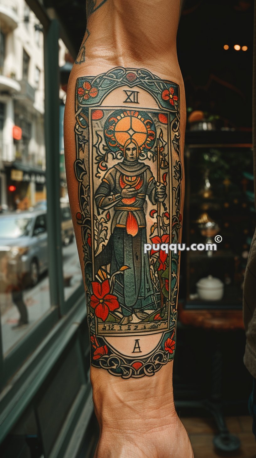 Forearm tattoo featuring an intricate, colorful design of a figure in medieval attire, with Roman numeral XII at the top and letter "A" at the bottom, surrounded by floral patterns.