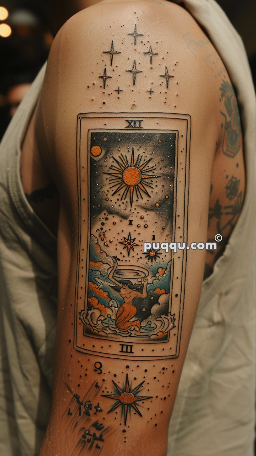 Tattoo of a tarot card on an upper arm, depicting a celestial theme with a sun, stars, and a figure in clouds, surrounded by additional star and geometric designs.