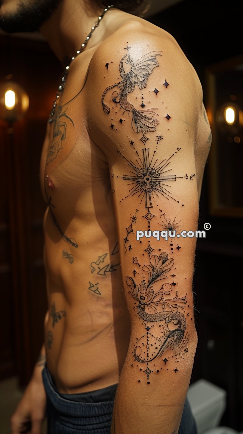 Man's arm with detailed black ink tattoos, including a dragon, compass rose, and various ornamental elements and stars.