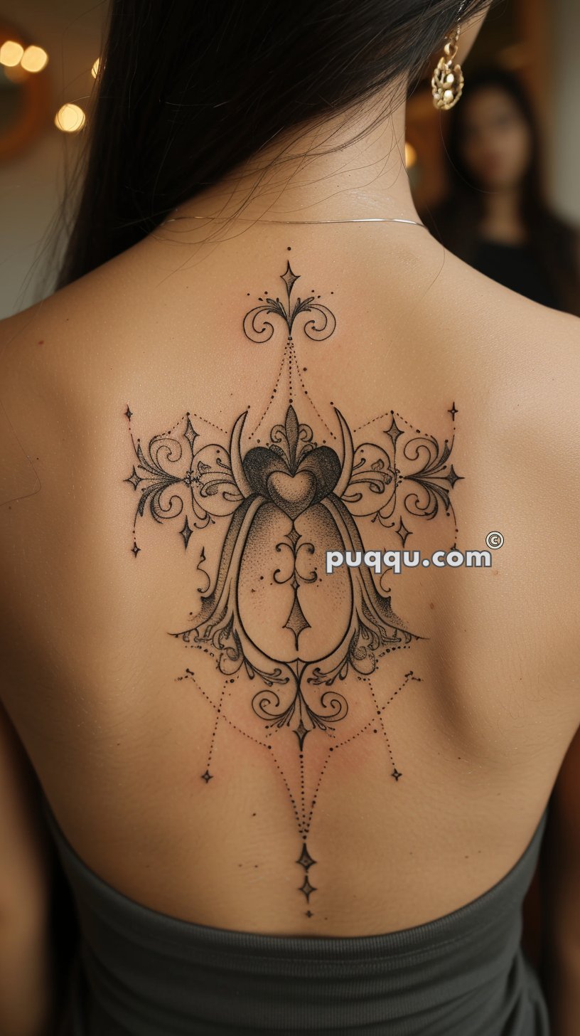 Intricate back tattoo with decorative and symmetrical designs featuring hearts, scrolls, and dots.