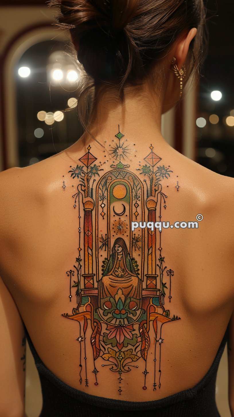 A detailed back tattoo featuring a stylized, ornate design with a seated figure inside an arched frame, surrounded by intricate patterns, celestial elements, and vibrant colors.