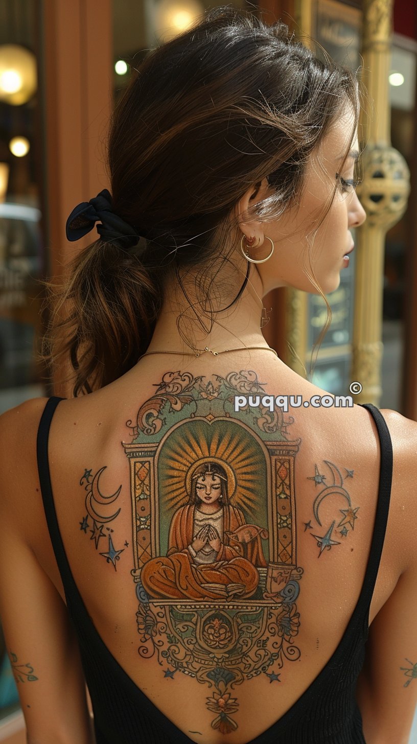 Woman with a large, intricate religious-themed back tattoo wearing a black tank top and gold hoop earrings.