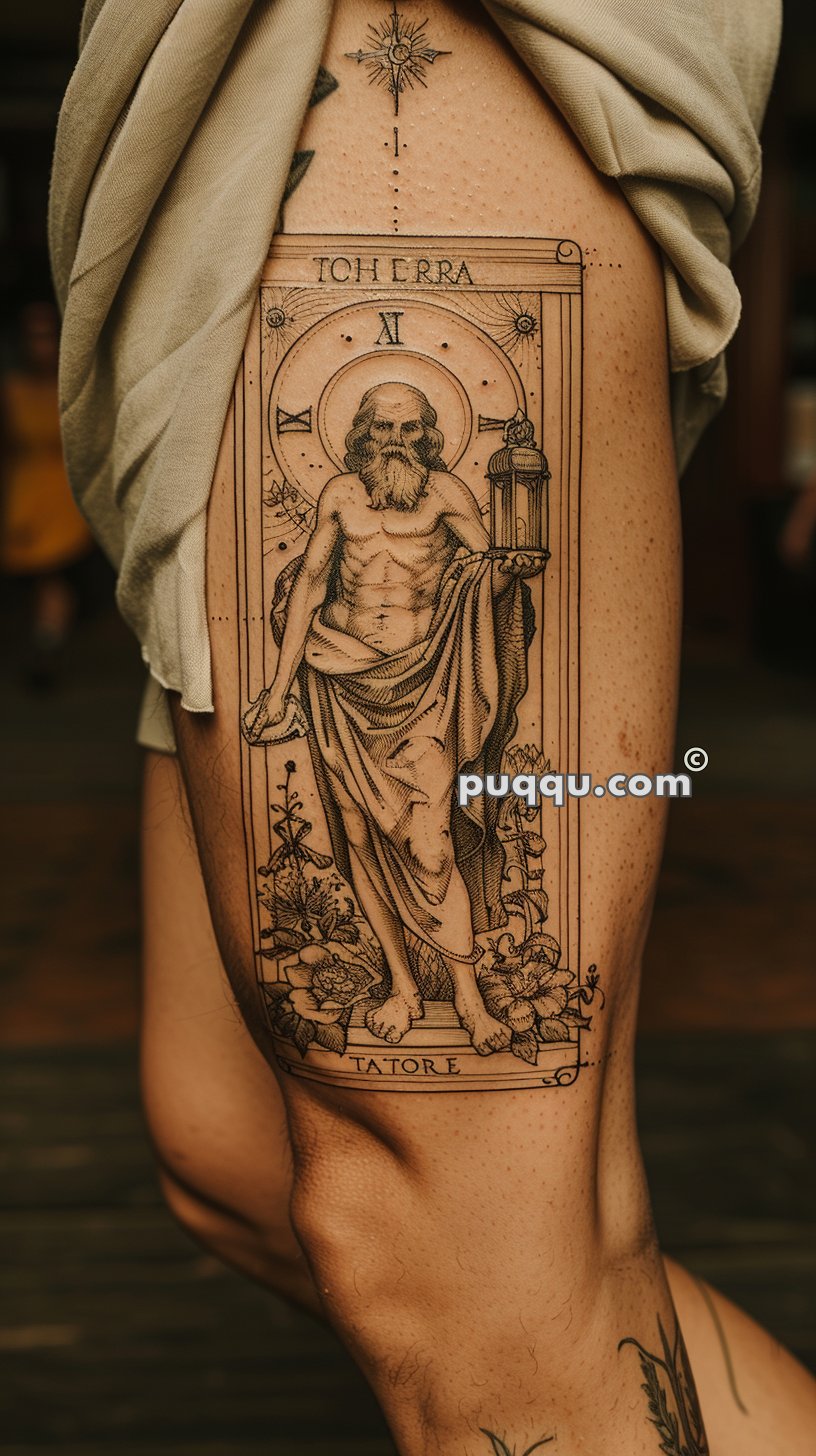 Tattoo of a bearded man holding a lantern, with floral and astrological elements, and the words "TOH ERRA," "TATORE."