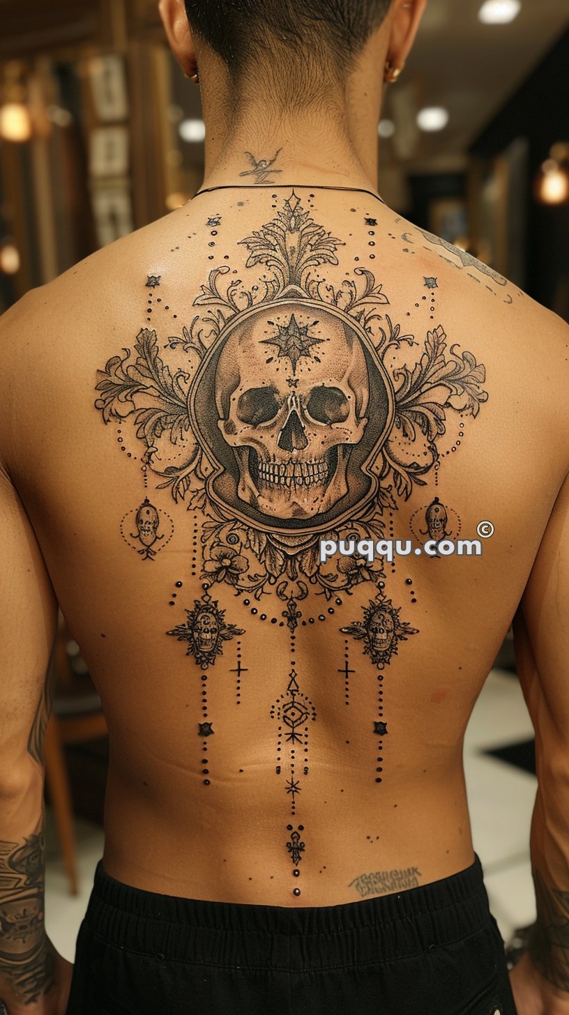 Detailed back tattoo featuring a large skull surrounded by intricate ornamental designs, lines, and dotwork patterns.