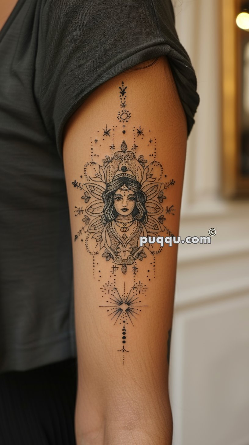 Detailed tattoo of a woman's face in an ornamental, mandala-like design on a person's upper arm.