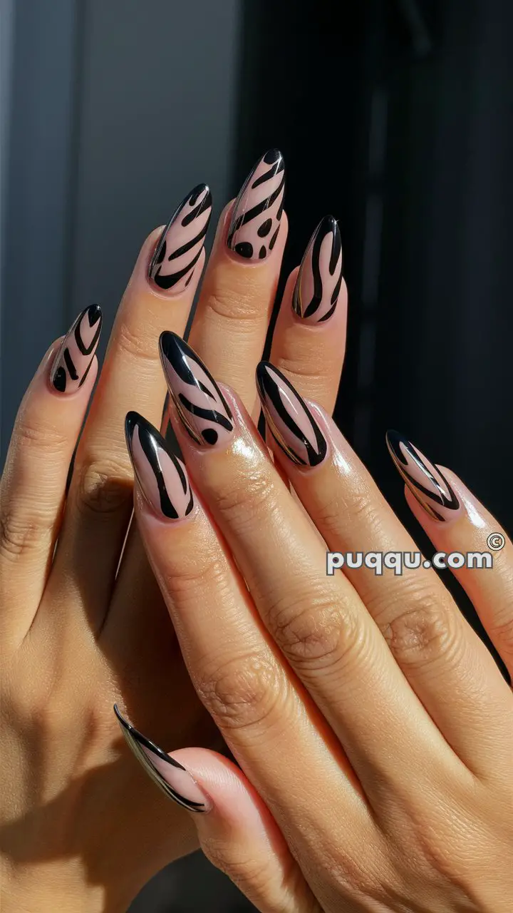 Hands with long almond-shaped nails featuring a black and nude abstract design.