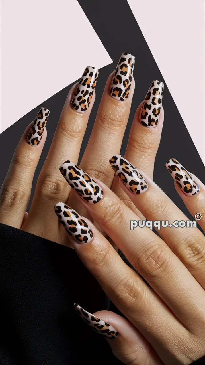 Close-up of hands with long, leopard print nail art against an abstract background.