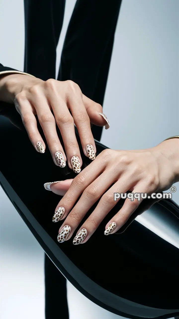 Close-up of hands with leopard print nail art on pointed nails, resting on a glossy black surface.