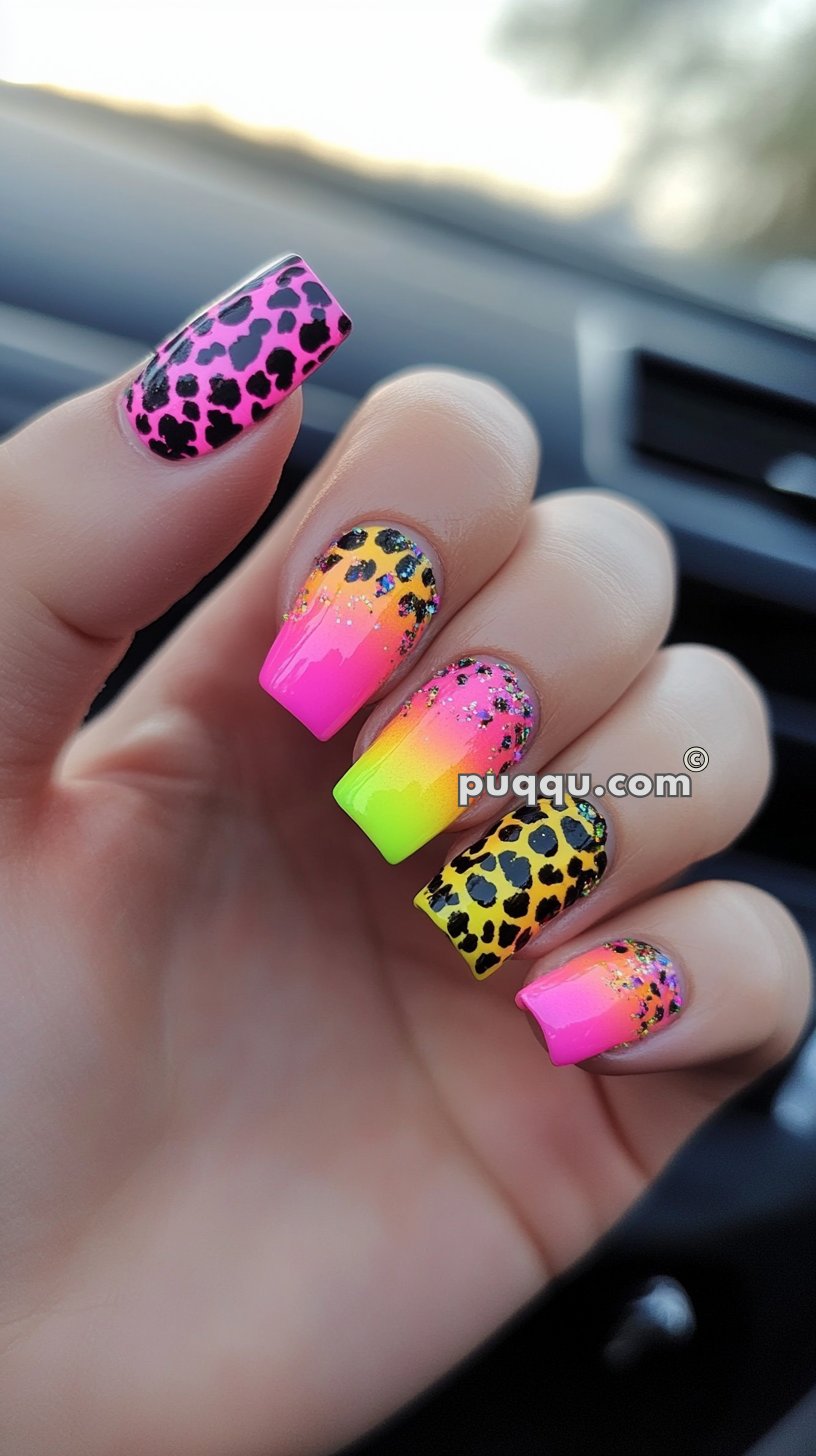 Close-up of hand with multicolored leopard print and gradient neon nail art.