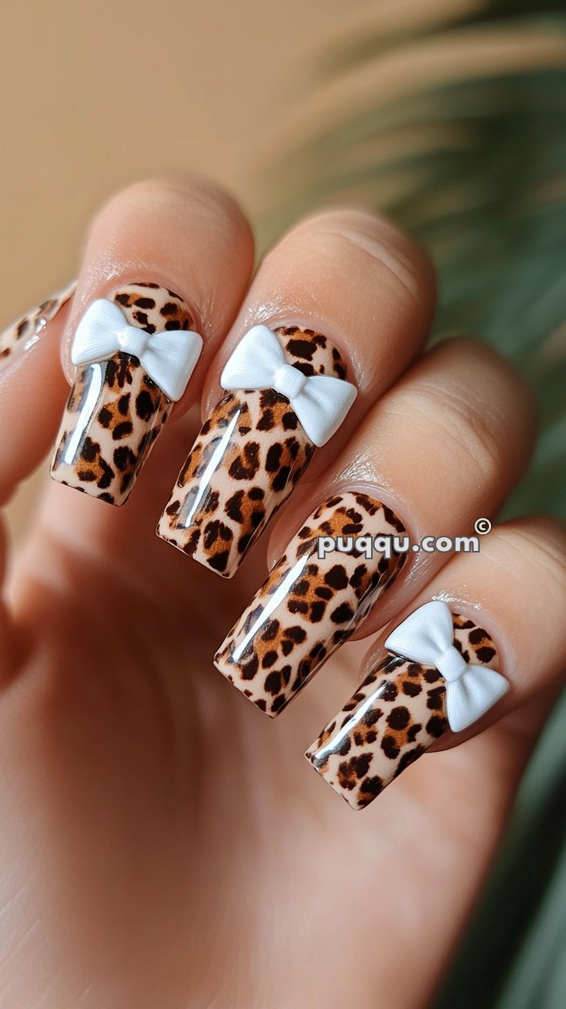 Leopard print nail design with 3D white bow accents.