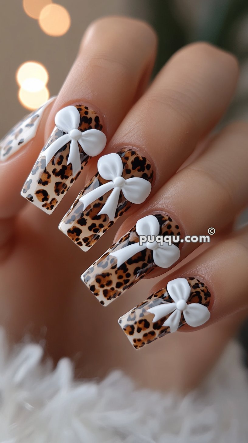 Leopard print nails with three-dimensional white bow decorations.