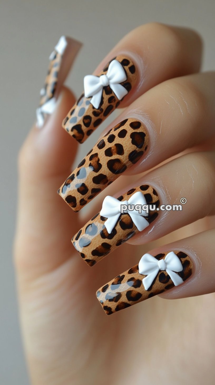 Long nails with a leopard print design and small white bows.