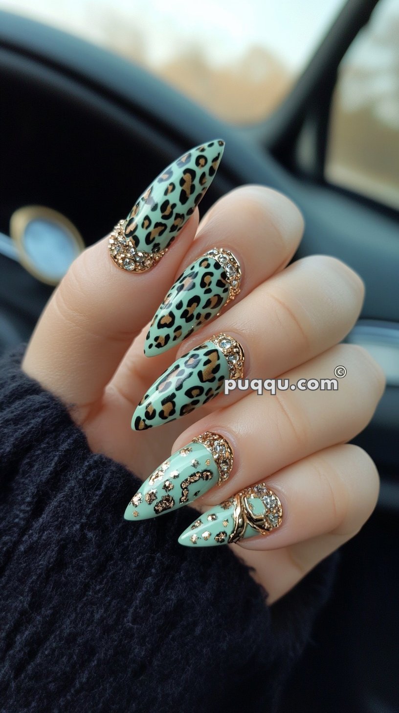 Mint green stiletto nails with leopard print and gold rhinestone accents.