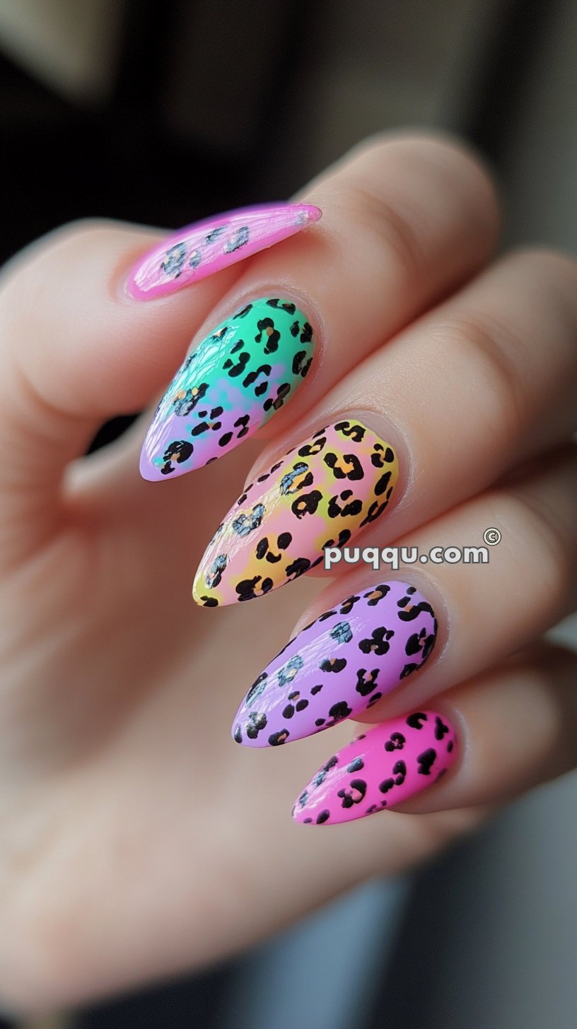 Colorful leopard print nail art on stiletto-shaped nails with gradients of pink, green, yellow, and purple.