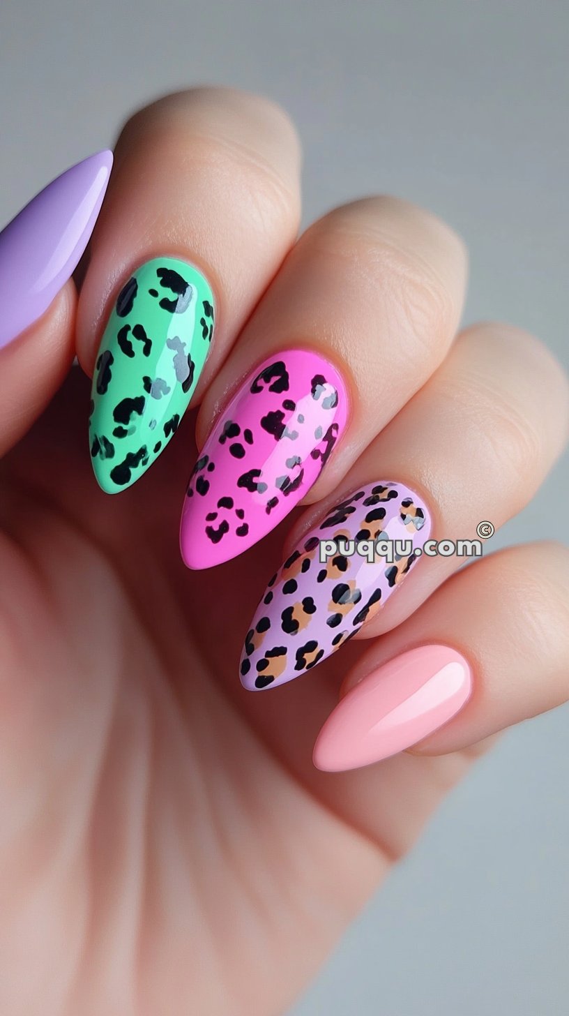 Colorful manicured nails with leopard print designs on mint green, pink, and lavender backgrounds, combined with solid lavender and pale peach nails.