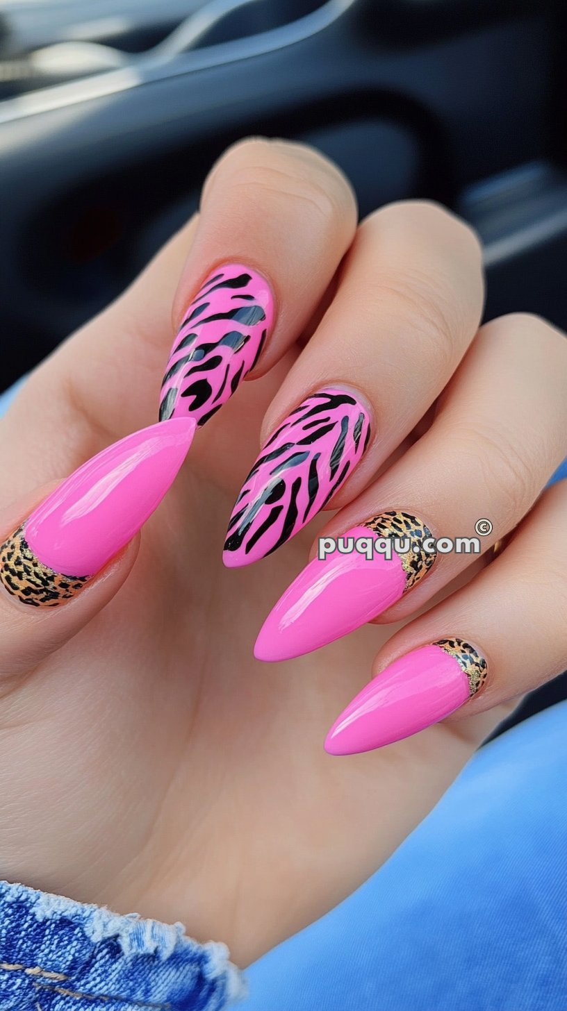 Hand with long, stiletto-shaped pink nails featuring black zebra print and gold cheetah print accents.