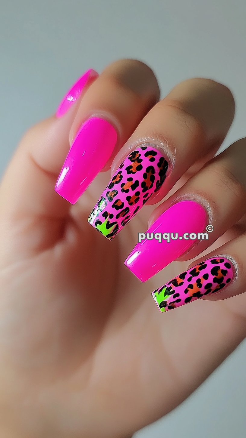 Hand with long nails painted neon pink, with two nails featuring a pink and green leopard print design.