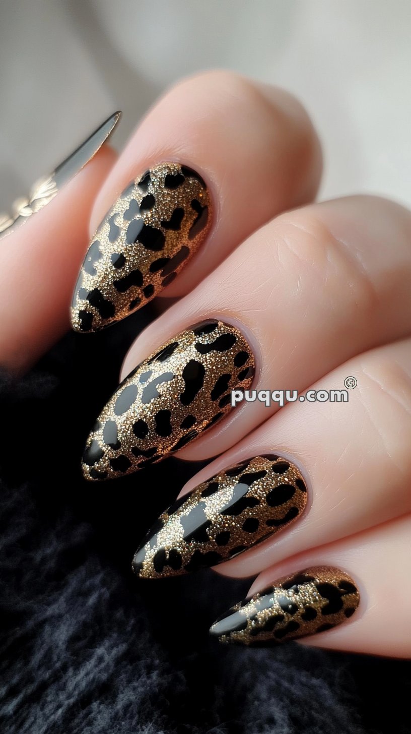 Close-up of a hand showing long, pointed nails with a black and gold leopard print design.