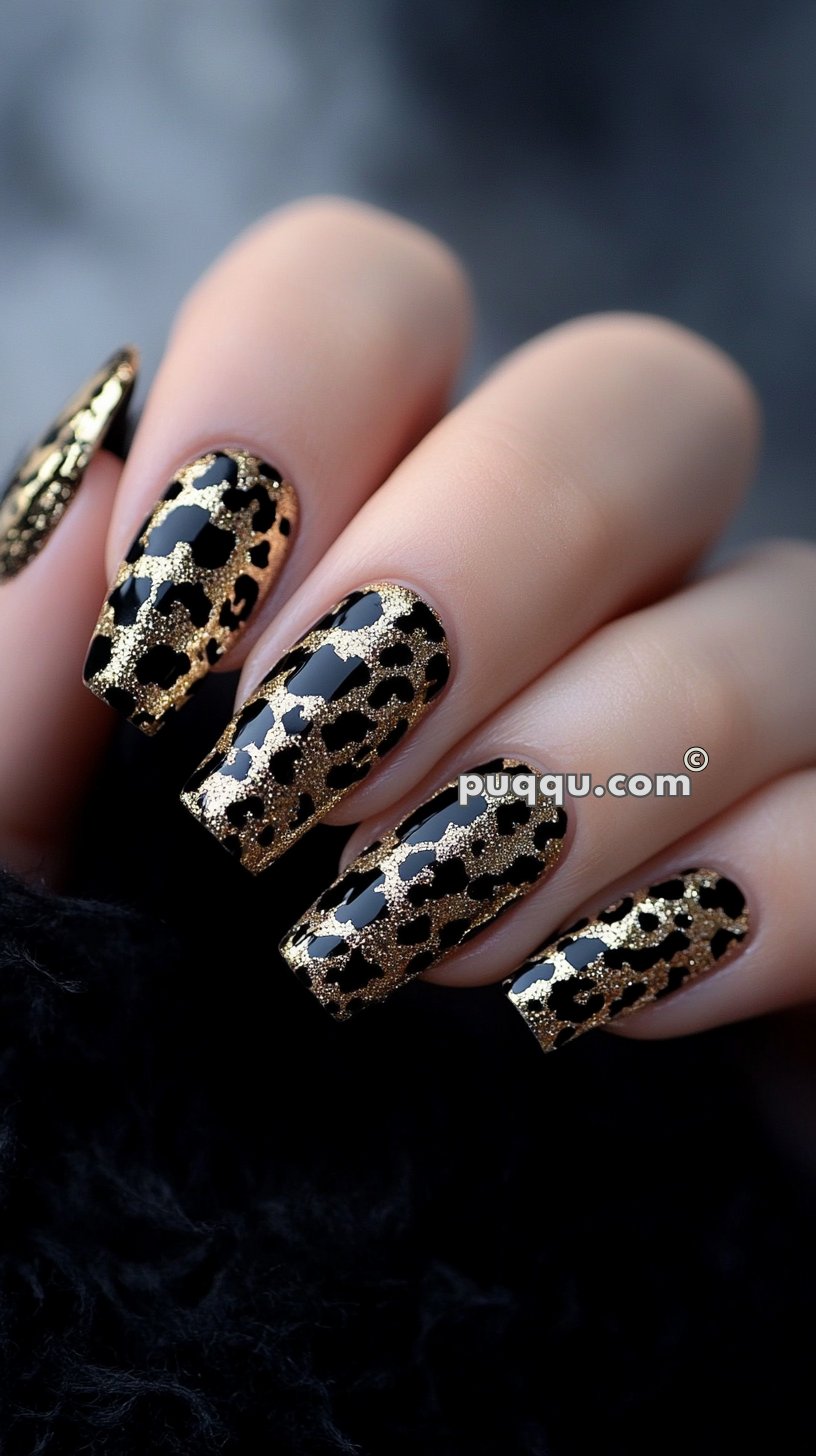 Black nails with intricate gold leopard print design.