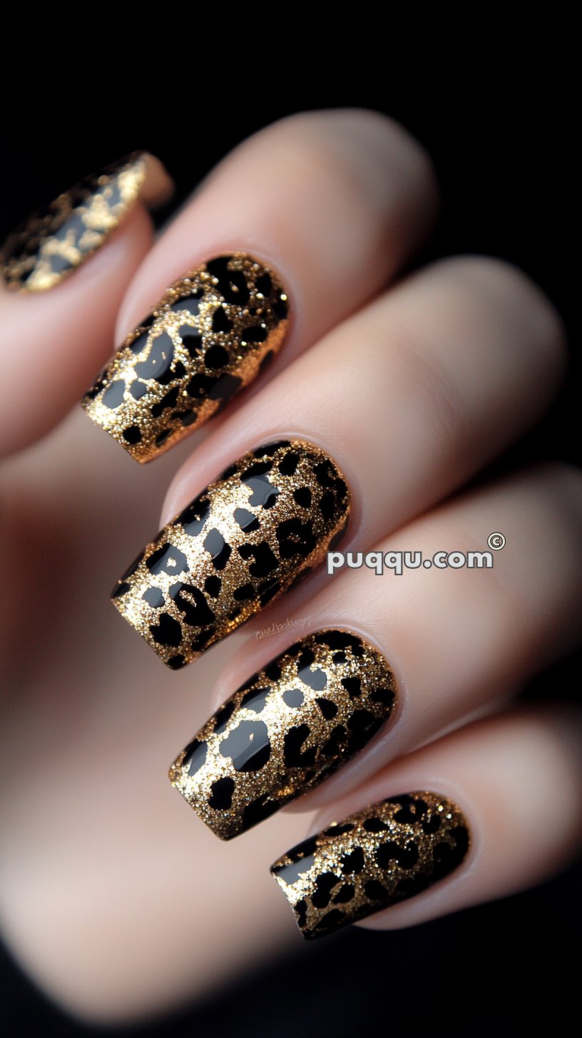 Close-up of a hand with long, rectangular nails featuring a black and gold glitter leopard print design.