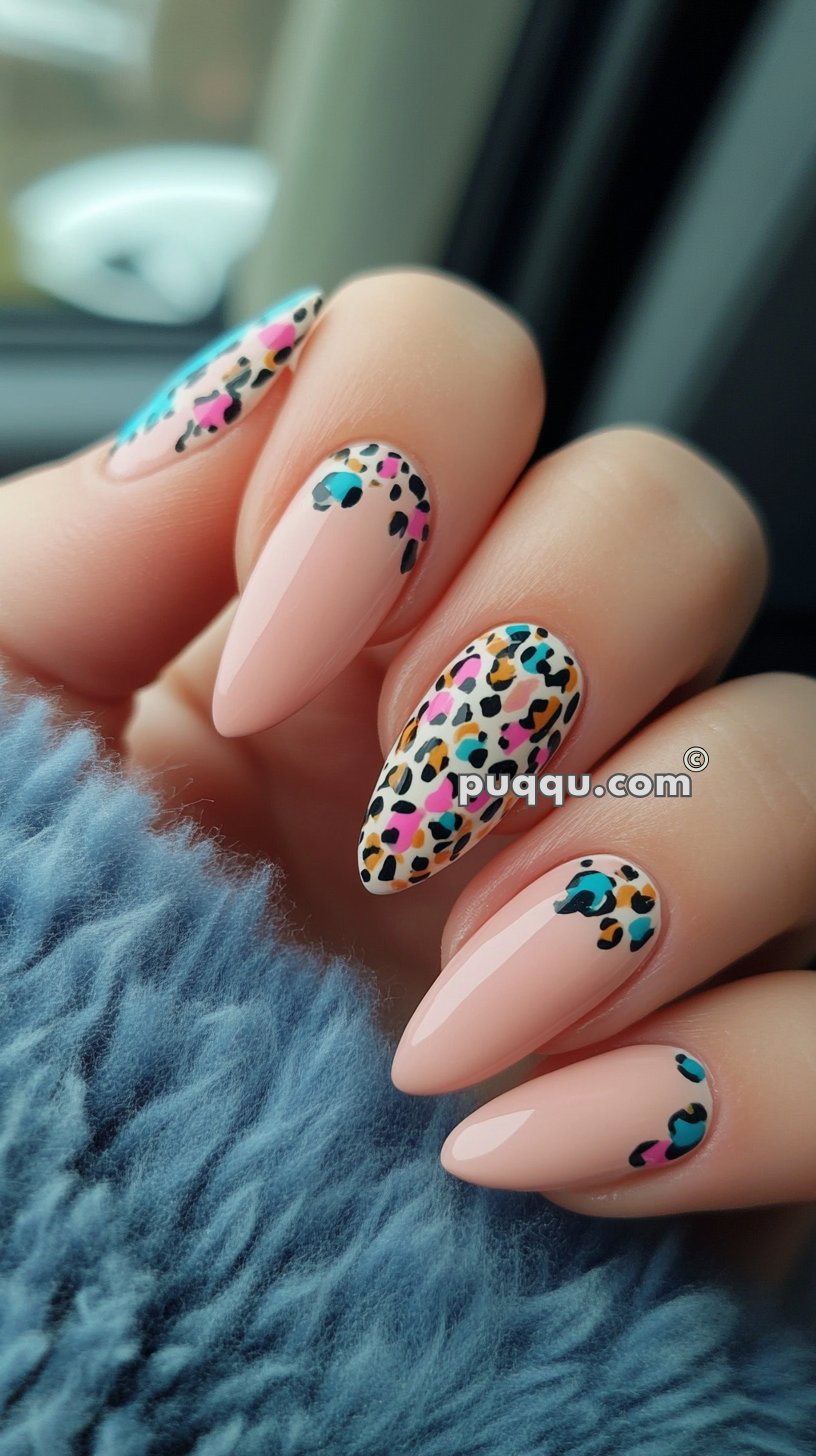 Close-up of hands with long, almond-shaped nails featuring a bright, multicolored leopard print design over a nude base.