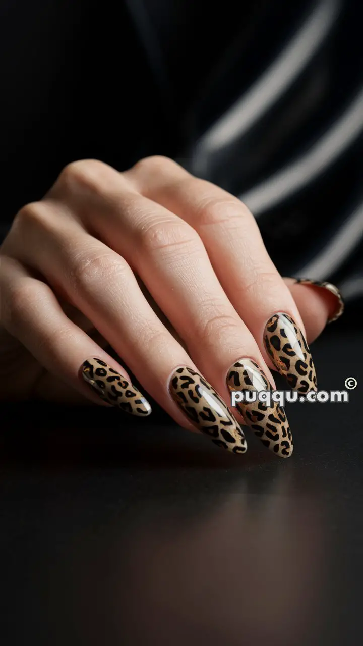 Close-up of a hand with long nails painted in a leopard print design.