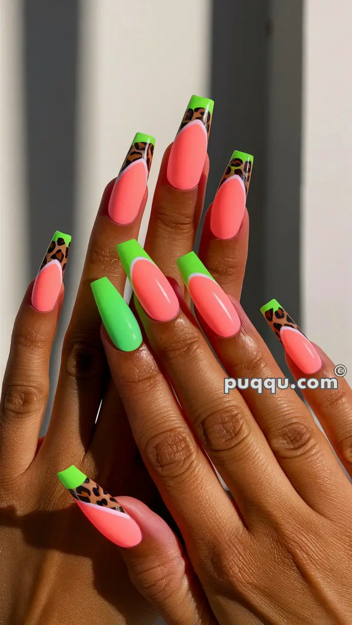 Hands with long, colorful acrylic nails featuring a mix of neon green, neon pink, and leopard print designs.