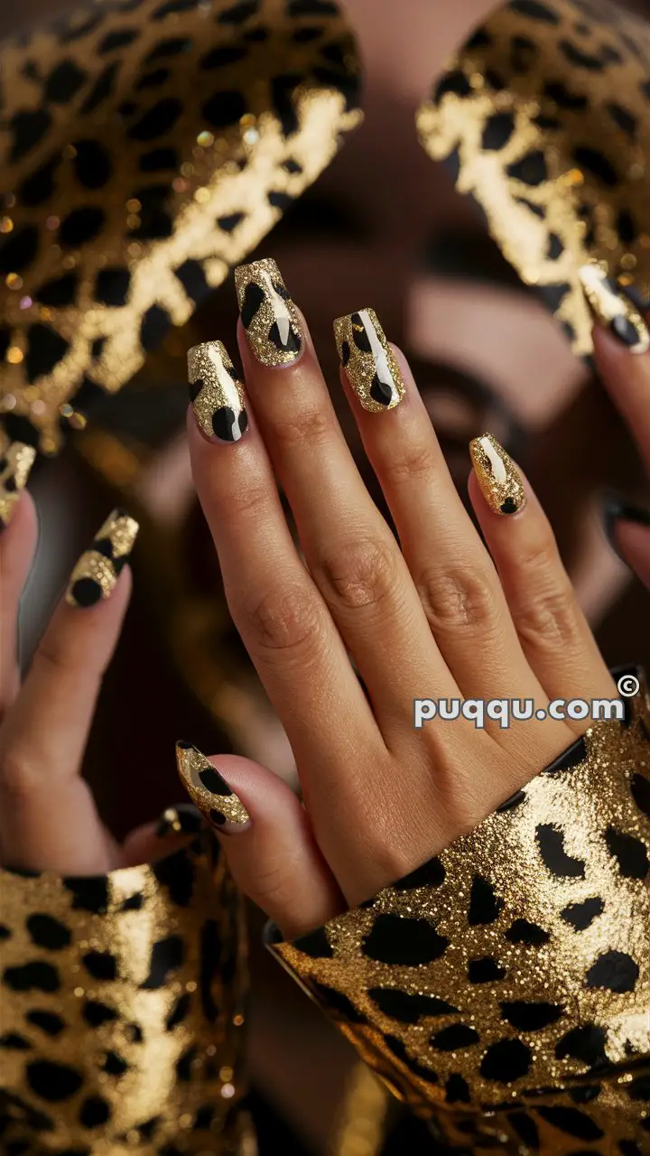 Hands with long nails featuring gold and black leopard print design, with matching leopard print fabric in the background.