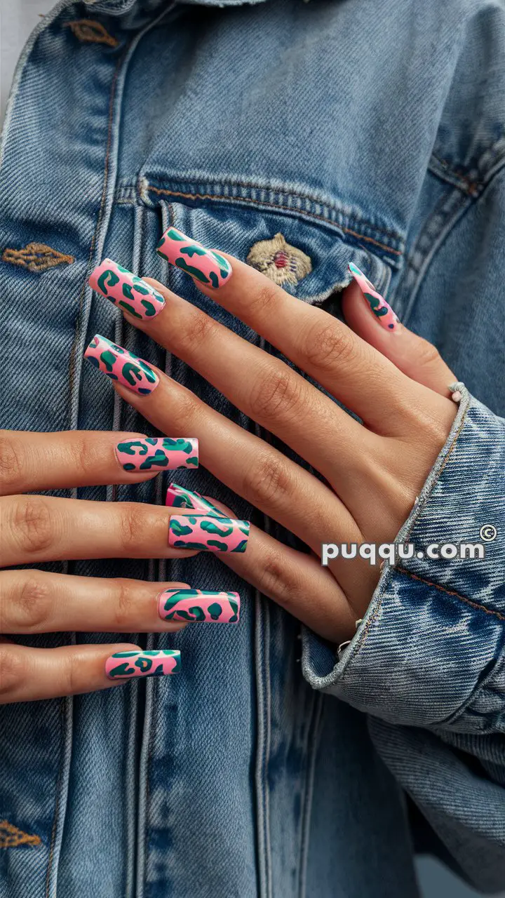 Hands with long, square-shaped nails featuring a colorful leopard print design, overlaid on a denim jacket.