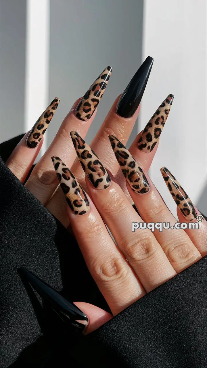 Long stiletto nails with a mix of leopard print and solid black designs.