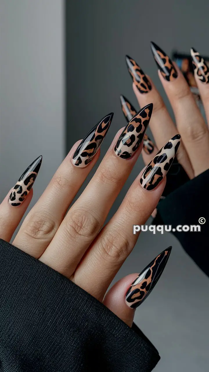 Hands with long, sharp, stiletto-shaped nails featuring a glossy leopard print design.