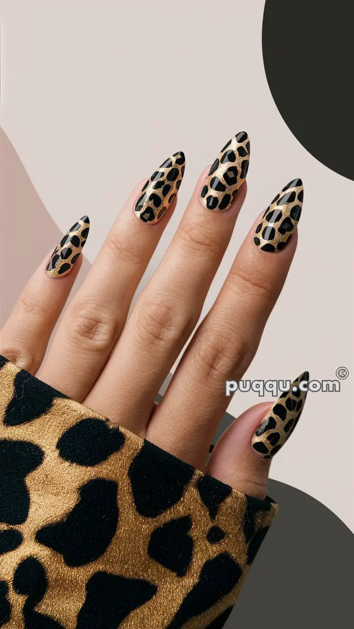 Hand with long, stiletto-shaped nails featuring a leopard print nail design and matching leopard print fabric.