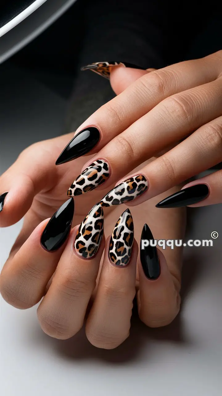 Stiletto-shaped nails with a glossy black and leopard print design.