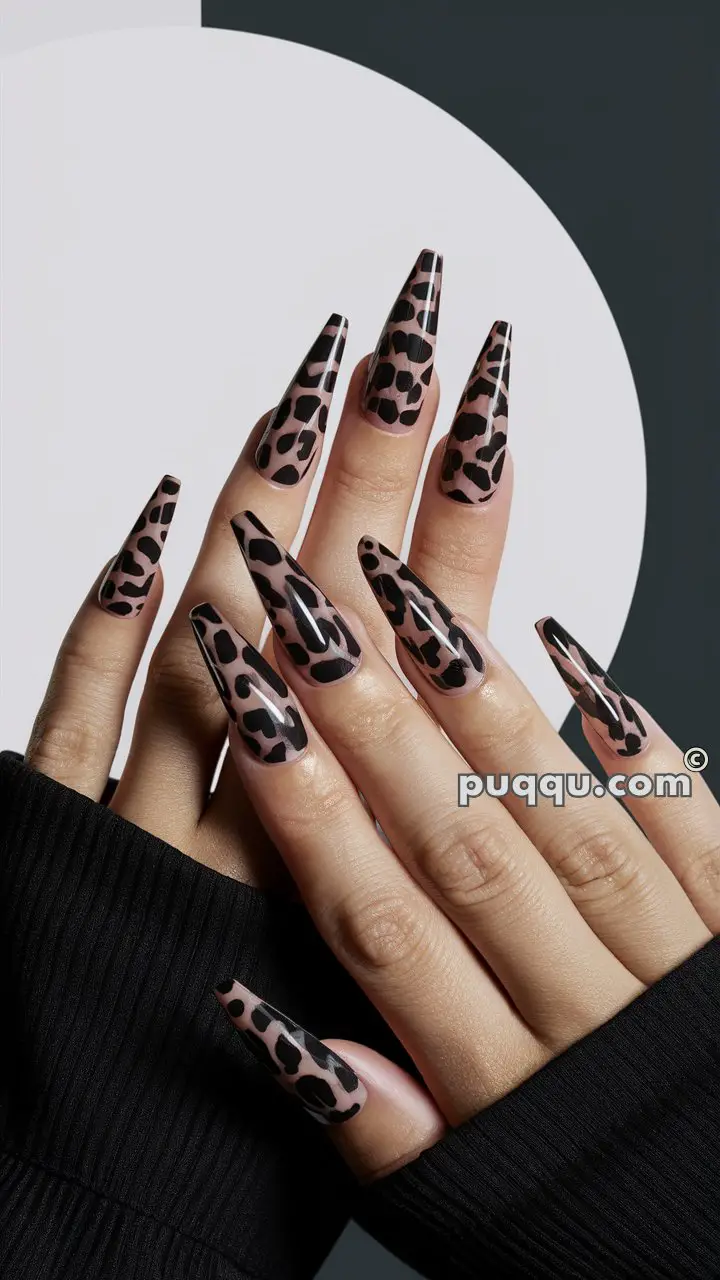 Hands with long, almond-shaped nails featuring a black and nude leopard print design.