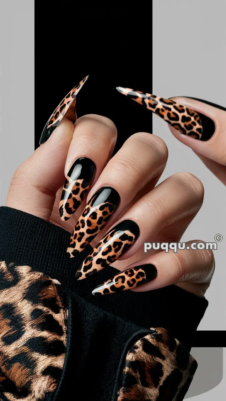 Hands with long, pointed nails featuring a black and leopard print design, matching a leopard print sleeve.