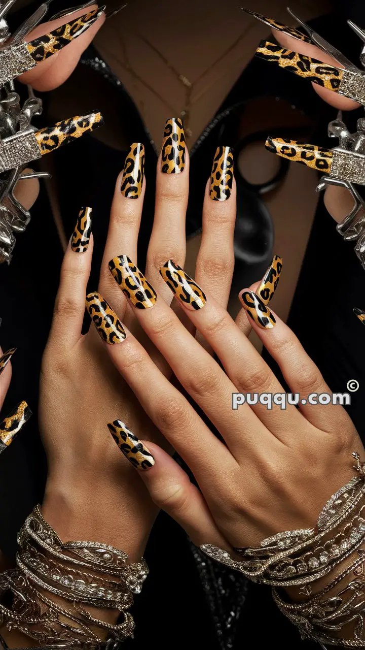 Hands with long, leopard-print nails, adorned with silver and jeweled bracelets on a dark background.