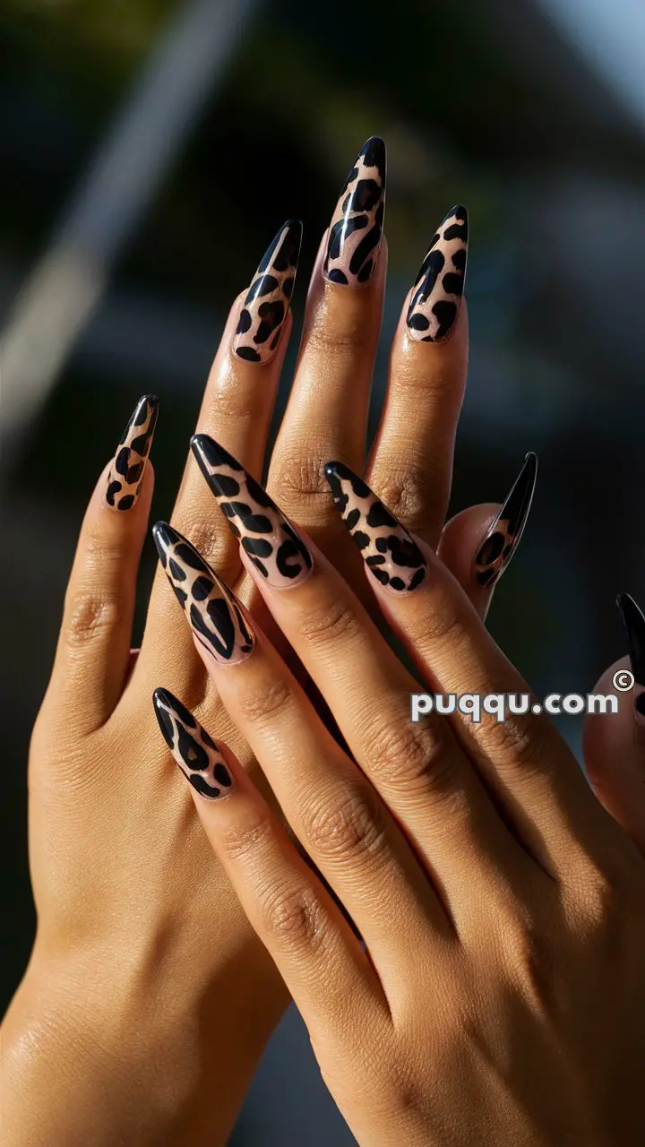 Hands with long stiletto nails featuring a leopard print design.