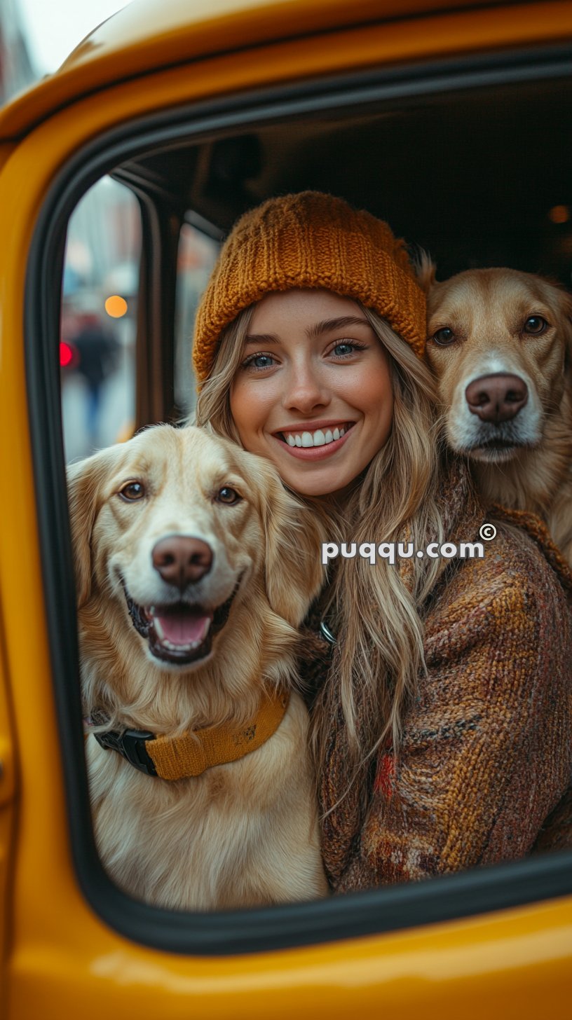 A woman wearing a knitted hat smiles while sitting in a car with two golden retriever dogs.