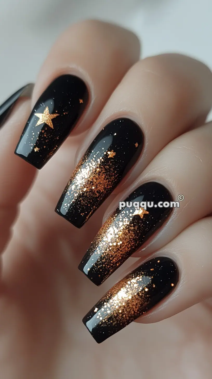 Black nail polish with gold glitter gradient and star accents.