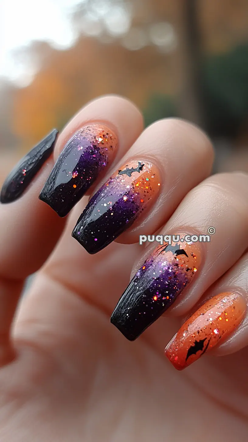 Halloween-themed nail art with a gradient of orange to black, glitter, and bat designs.