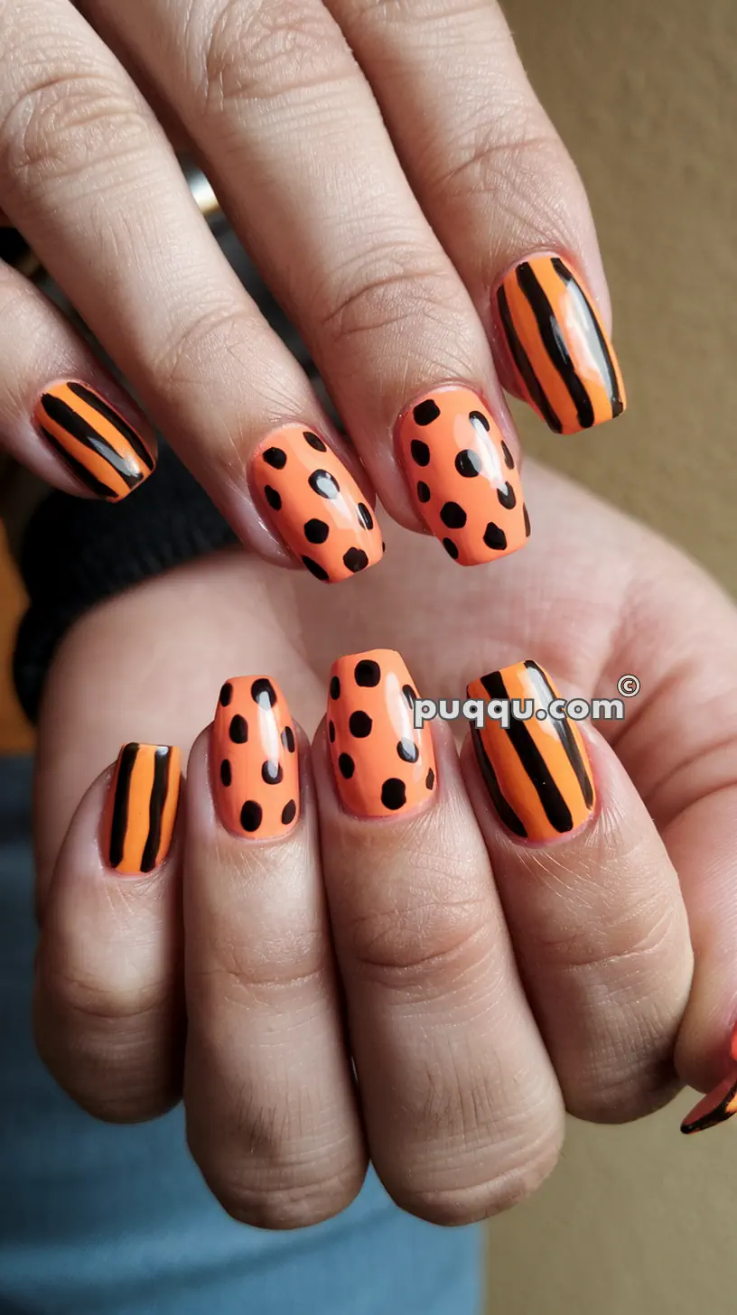 Orange fingernails with black polka dot and stripe designs.