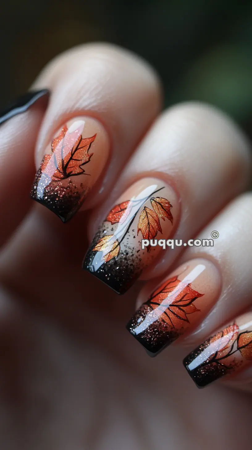 Close-up of fingernails with fall-themed nail art featuring orange leaves and black glitter tips.