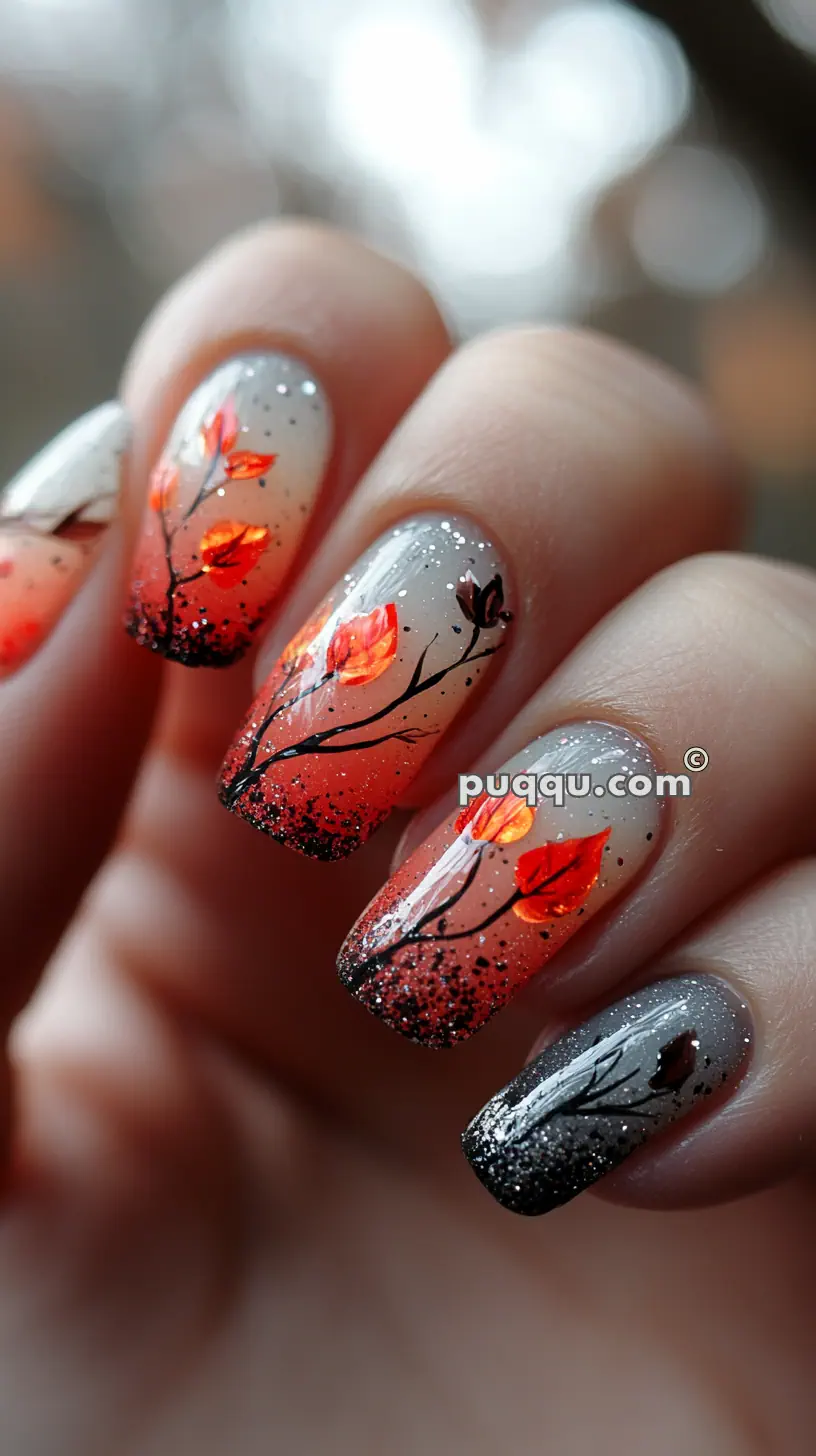 Close-up of nails with autumn-themed nail art, featuring gradient gray to orange background, black tree branches, orange fall leaves, and glitter accents.