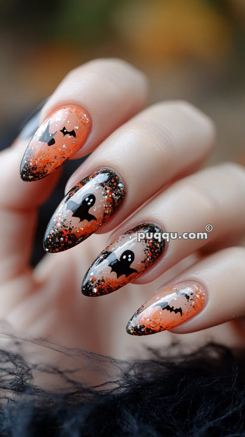 Halloween-themed nails with orange and black gradient, featuring bats, ghosts, and glitter accents.