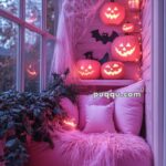 Cozy corner with pink pillows and fluffy blanket decorated for Halloween with glowing jack-o'-lanterns, fake spider webs, and bat cutouts.