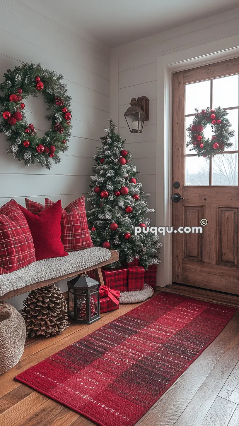 Cozy holiday-themed entryway with plaid pillows, a Christmas tree adorned with red ornaments, and a festive wreath on the door.